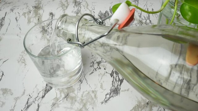 Top view of tap water poured into glass on marble clean white background potos plant. Purity, rebirth, nature, health