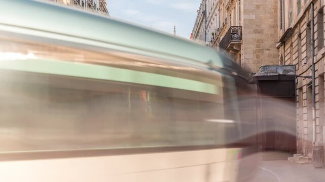 Timelapse of Bordeaux Cathedral (Cathedrale Saint Andre) from Vital Carles street, featuring a moving tram in the historic city. People wait at the tram stop. A symbol of Bordeaux's heritage. France