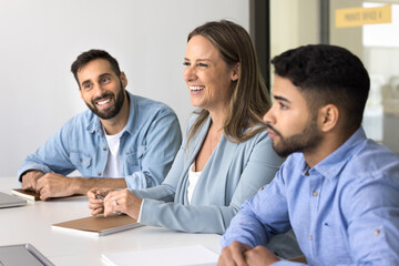 Happy diverse teammates discussing business related matters. Company staff members gathered at...