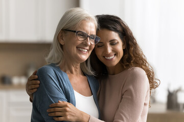 Portrait affectionate caring young woman grown up child daughter hold in arms hug embrace with...