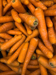 Fresh carrots neatly displayed in a mall container.