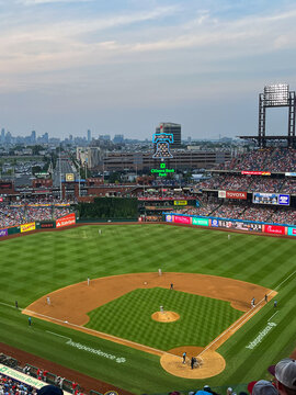 A baseball field with a large crowd watching the game