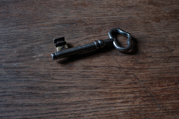 An old key lying on a wooden tabletop