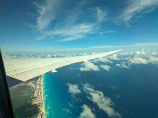Stunning airplane window view of the Mexican coastline near Cancun, showcasing turquoise waters and...