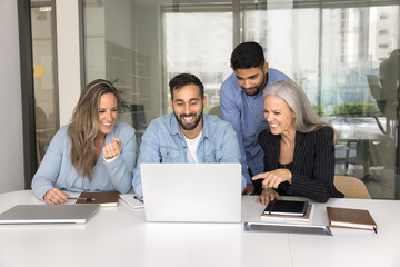 Happy workmates using laptop in conference room, working on joint online task or project, take...