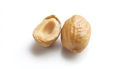 Close-up of a whole and halved hazelnut on white background.