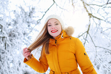 portrait of a girl in a yellow jacket in a winter forest, frame shot from bottom to top