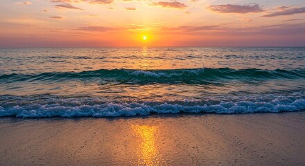 A tranquil beach at sunset with waves that sparkle as they crash