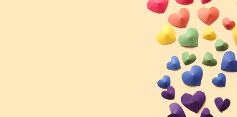 Colorful hearts made of paper on yellow background. LGBT concept