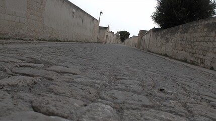 Cobblestone street between high stone walls.
