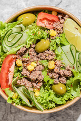 salad with tuna, tomatoes, cucumber and olives in container
