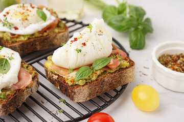 Grid of tasty sandwiches with egg on grey background
