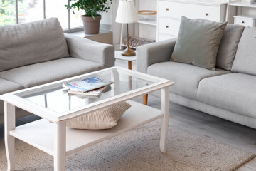 Interior of light living room with grey sofas and coffee table