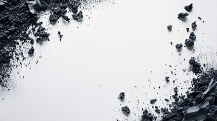 Crumbled black clay forming a frame on white background