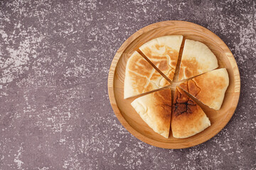 Plate with pieces of tasty pita bread on grey background