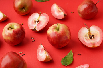 Sweet pink apples and seeds on red background