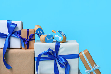 Stack of different gifts for Hanukkah celebration and dreidels on color background, closeup