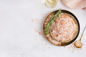 Plates with Himalayan pink salt and rosemary on white background