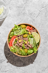 salad with tuna, tomatoes, cucumber and olives in container