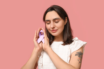 Pretty young woman with light purple ribbon on pink background. Testicular cancer awareness concept