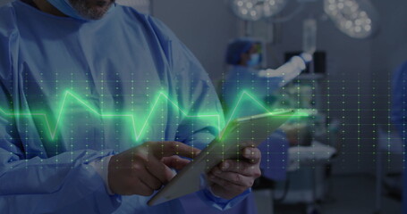 Image of cardiograph over diverse surgeons during surgery