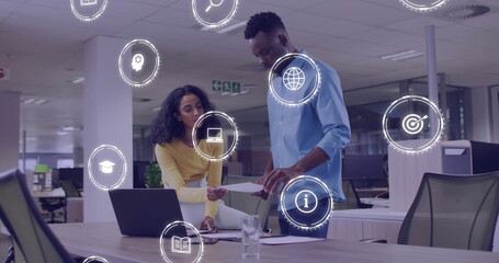 Image of business icons over diverse colleagues talking in office