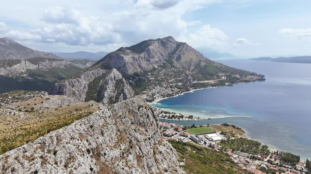 Flight over the coastal mountain range towards town Omis, Croatia. Aerial footage