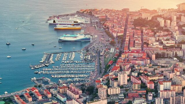 Cruise ship docked in bustling Corsica's Ajaccio harbor during sunset