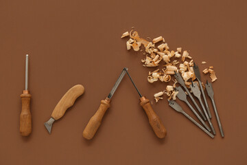 Carpenter's tools and wood shavings on brown background