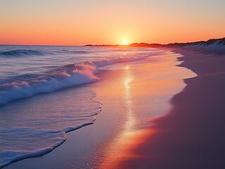 Vibrant sunset over ocean waves on sandy beach.