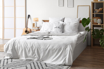 Interior of teenager's room with bed, guitar and folding screen