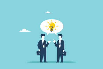 Two young entrepreneurs discussing business with a message bubble symbol containing a glowing light bulb