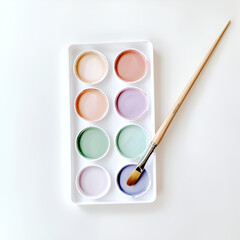 Fototapeta premium Pastel watercolor paints and brush ready for artistic creation. Soft hues and a clean aesthetic.