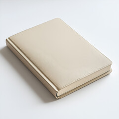 Fototapeta premium Beige notebook, blank cover, closed, on white background. Perfect for mockups or showcasing designs.