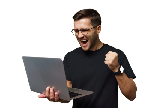 Excited young man celebrates success while working on a laptop at home