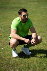 Young Man Squatting During Outdoor Training Break