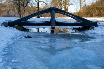 Beautiful frozen stream under a bridge in a park in Lund Sweden