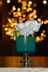 雲をイメージしたわたあめが乗った青いカクテル © YS