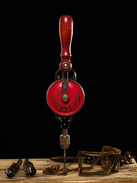 old chignole or handdrill on black background surrounded with old style protection glasses and  drill bits