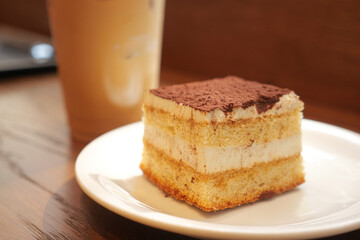 Delicious Tiramisu Cake and Iced Coffee on a Wooden Table