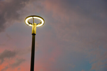 Modern street lamp illuminated by a vibrant sunset sky