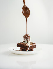 Rich and decadent chocolate brownies topped with creamy vanilla ice cream, drizzled with melted...