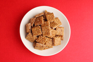 Sesame seed jaggery chikki or til ke chkki and tilgul or til gul ladduchikki served in bowl for Makar Sankranti Festival in India
