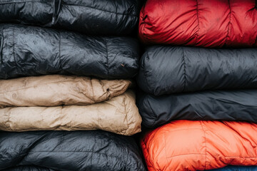 A stack of colorful blankets, including a tan one