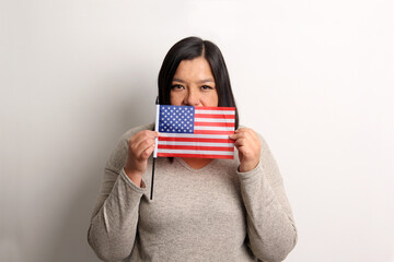 40-year-old Latina woman shows the United States flag proud and happy to obtain nationality to...