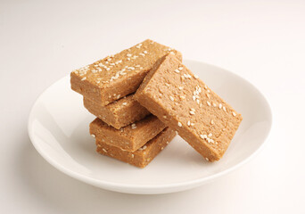 Sesame seed jaggery barfi or til ke gul   barfi and tilgul or til gul barfi 
 served in bowl for Makar Sankranti Festival in India