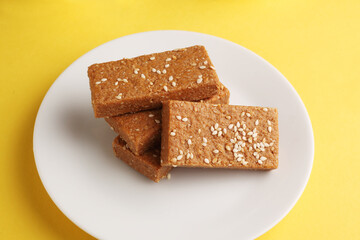 Sesame seed jaggery barfi or til ke gul   barfi and tilgul or til gul barfi 
 served in bowl for Makar Sankranti Festival in India