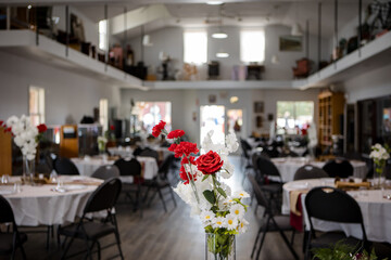 Beautiful red roses and daisies at the front of a wedding reception