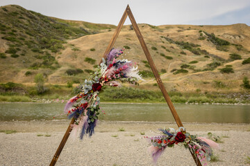 Elegant wooden outdoor wedding arch for ceremony with flowers
