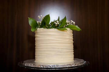 Elegant white wedding cake with beautiful green leaves